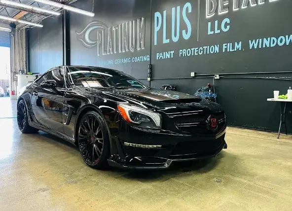 Black Mercedes SL in front of the Platinum Plus Detailing LLC wall